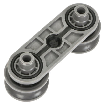 A gray plastic and rubber automotive pulley system component with two wheel assemblies and a central bearing, shown on a plain white background.