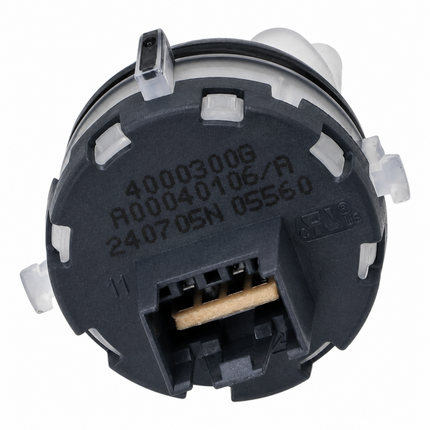 A close-up of a circular black plastic automotive component with molded white plastic tabs, a terminal connector with a tan wire, and embossed serial numbers on the top surface, isolated on a white background.
