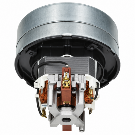 A close-up studio shot of a small electric motor or dynamo with a brushed silver metal outer ring, black internal housing, copper windings, and silver metal core components on a plain white background.